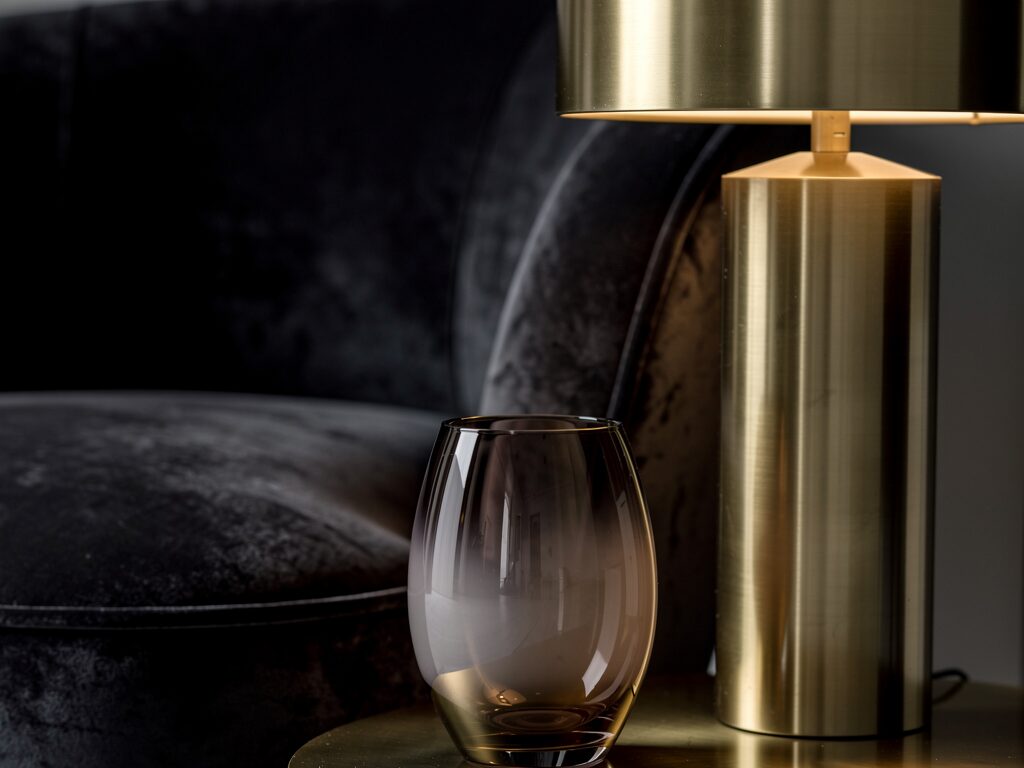 グレージュのラグとネイビーのソファを中心に、スモークガラスのローテーブルで抜け感を出したモダンな都會的リビング